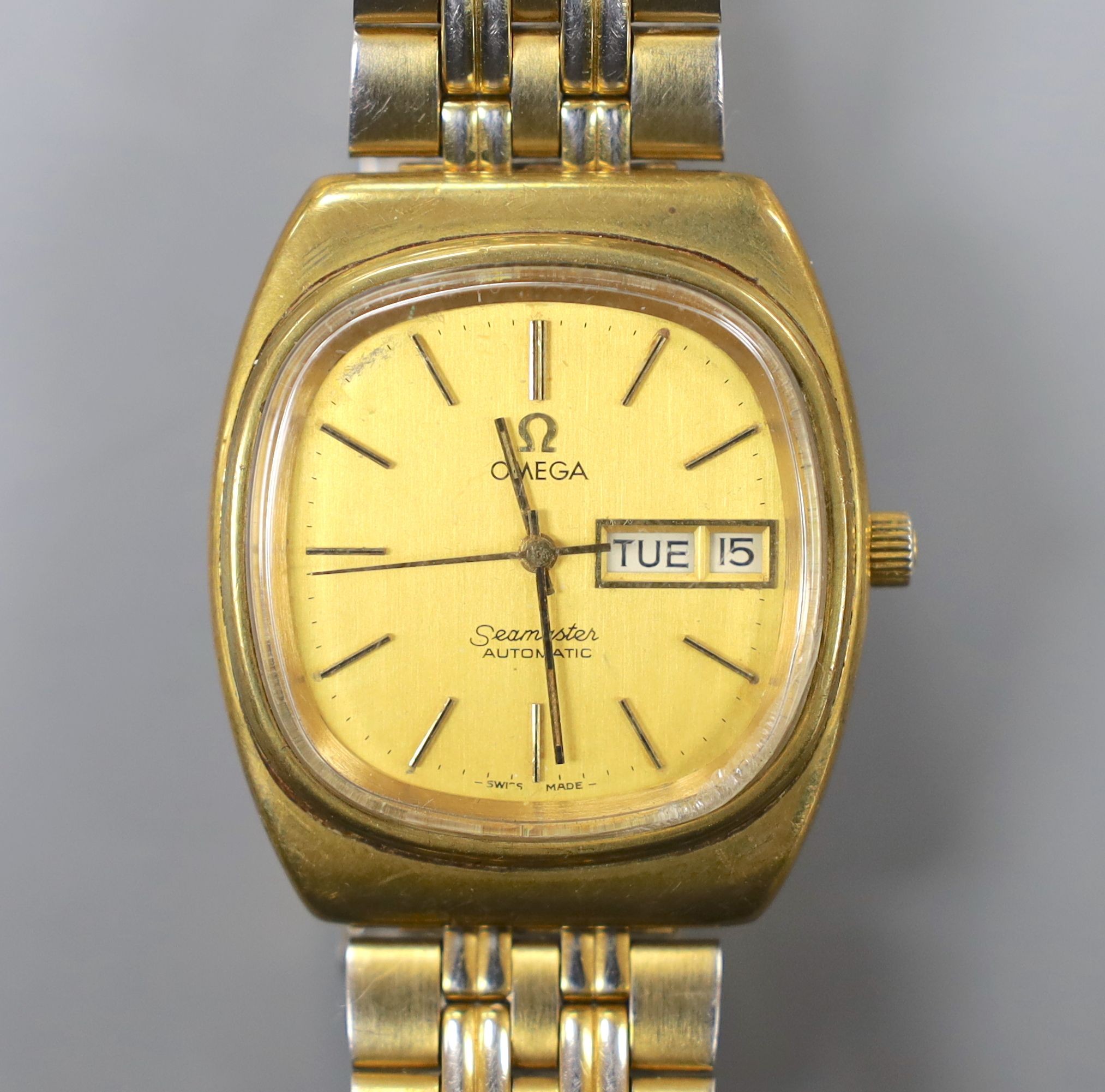 A gentleman's steel and gold plated Omega Seamaster automatic day/date wrist watch, on associated bracelet, case diameter 35mm.